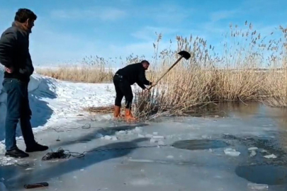 Yüzeyi donmuş nehirde buzu kırıp balık avlıyorlar